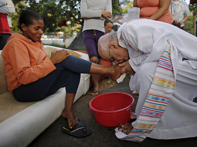 Priest Julio Lancellotti washes the feet of a homeless woman on a street, during the Holy Thursday celebration in Sao Paulo, April 2, 2015. REUTERS/Nacho Doce